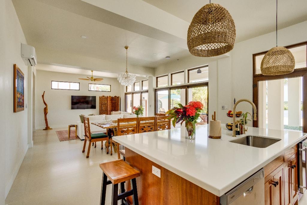 Open-plan kitchen island with quartz countertop, dining area and living room beyond